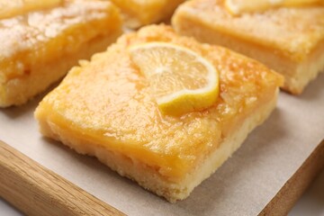 Tasty lemon bars on board, closeup view