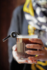 Woman Hands holding a cup of coffee with a straw