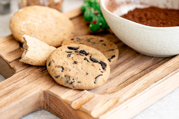 Close-up, homemade chocolate chip cookies on a wooden cutting board.
