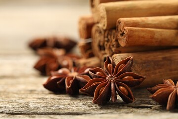 Cinnamon sticks and star anise on wooden table, closeup. Space for text