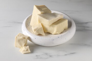Pieces of tasty white chocolate on marble table