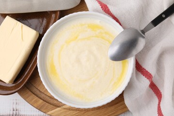 Bowl of delicious semolina pudding with butter served on table, top view