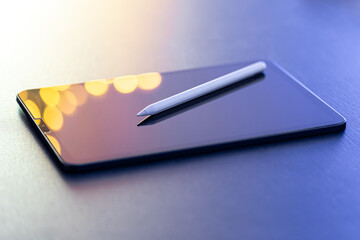 Digital tablet and stylus pen on the table close-up.