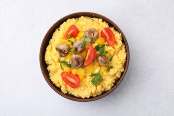 Tasty cornmeal with tomatoes, pepper and mushrooms in bowl on light table, top view