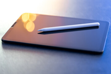 Digital tablet and stylus pen on the table close-up.