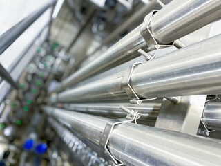 Stainless steel pipes in the factory. Construction on food production, industry background. - obrazy, fototapety, plakaty
