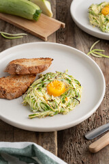 Breakfast of zucchini and eggs on a wooden background. Healthy breakfast with vegetables and eggs.