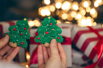 Gingerbread Christmas cookies in the form of fir trees in female hands.