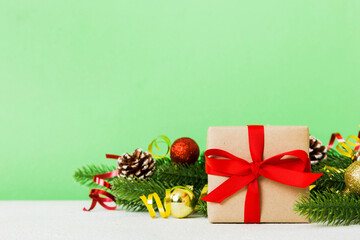 New Year Christmas mood, gift box, branches of a christmas tree, New Year decorations on a colored background
