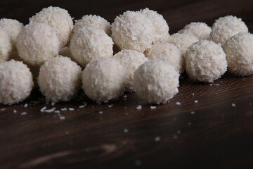photo, a set of homemade coconut candy balls showcases their round, tempting charm against a clean dark backdrop. These tasty confections promise a delightful dessert or snack