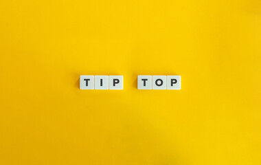 Tip Top on Letter Tiles on Yellow Background. Minimal Aesthetic.