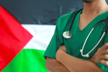 Male doctor standing in folded arms with Palestine flag on the background