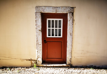 Old wooden door with a white window on a wall in the background inTagus Port Belem Lisbon