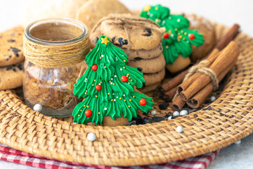 Gingerbread in the shape of a Christmas tree and cookies in a wicker plate.