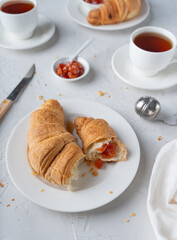 French breakfast with croissant and jam. Table setting for breakfast. Tea party with baked goods.
