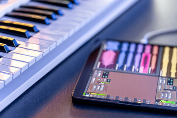 Musical keys and a tablet with a stylus on the table.
