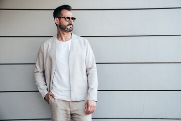 Handsome confident stylish hipster lambersexual model. Sexy modern man dressed in elegant white...