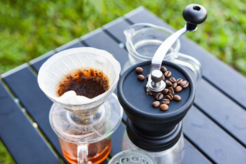 drip coffee barista pouring water on filtered brewing, make cup hand drip coffee in glass jar on outdoors.
