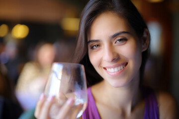 Happy restaurant customer holding water glass