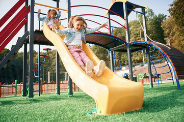 On the playground slide. Kids are having fun