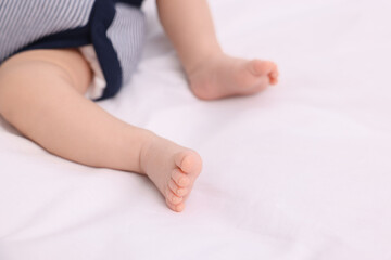 Newborn baby lying on white blanket, closeup. Space for text