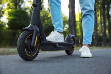 Man with modern electric kick scooter in park, closeup