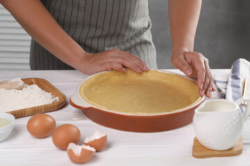 Woman making quiche at white wooden table, closeup