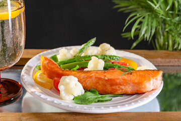 Healthy meal. Piece of tasty grilled salmon with vegetables on tray, closeup