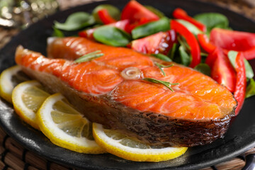 Healthy meal. Tasty grilled salmon with vegetables and lemon on plate, closeup