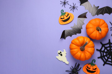 Flat lay composition with bats, pumpkins, ghost and spiders on purple background, space for text. Halloween celebration