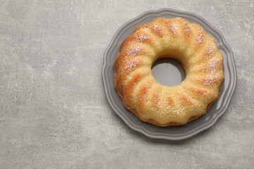 Delicious freshly baked sponge cake on gray table, top view. Space for text