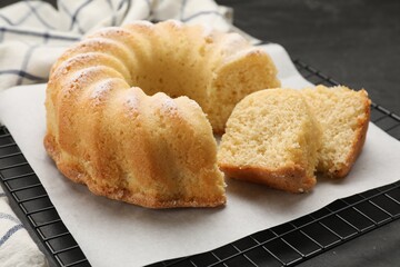 Delicious freshly baked sponge cake on black table, closeup