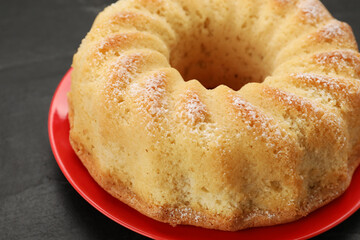 Delicious freshly baked sponge cake on black table, closeup