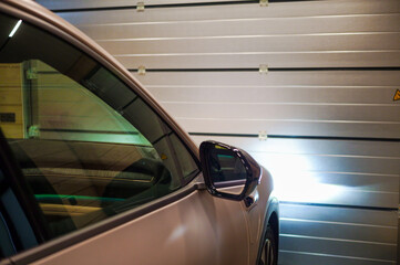 a car in front of metal roller garage doors, indoor shot, no people