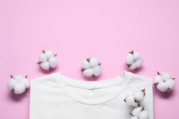 Fluffy cotton flowers and white t-shirt on pink background, flat lay. Space for text