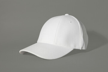 Stylish white baseball cap on grey background