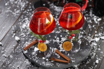 Christmas Sangria cocktail in glasses and snow on dark wooden table