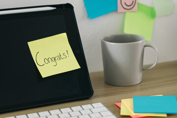 Sticky notes with Congratulation text on computer screen