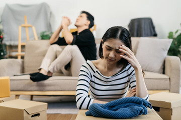 Unhappy young couple sitting apart, having problems in relationship, thinking of breaking up or...