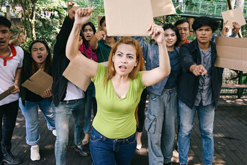 Woman activist leading the demonstrations, raising hands and holding blank cardboard