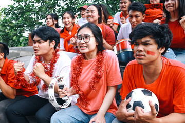 Nervous football fans watching soccer match, emotionally cheering team at stadium during game