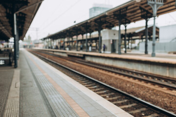 Fototapeta na wymiar Blurred background of empty train station. Blurred scenery of the platform