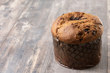 Christmas panettone cake with chocolate chips on wooden table. Copy space