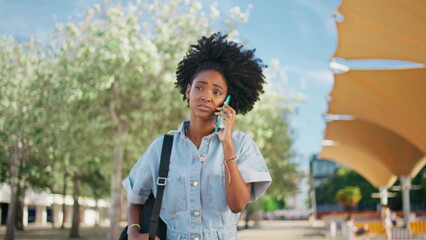 African girl complaining mobile phone walking city street close up. Sad teenager