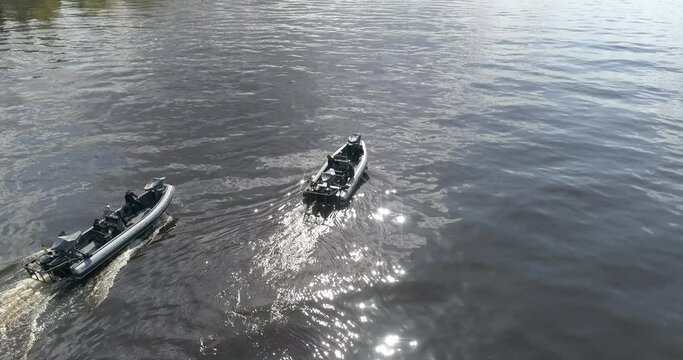 A high-speed patrol boat in the river. The boat patrols the water surroundings. Patrol boats sail along the river as seen from a drone.