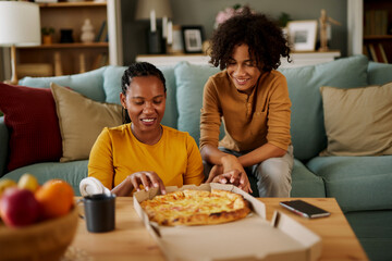 Mother and teenage son having pizza at home