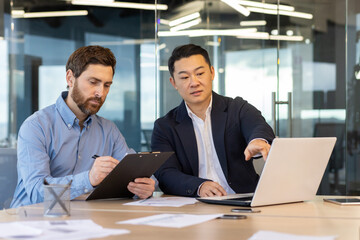 Business meeting, two business people serious concentrated discussing strategy and plans, sitting...