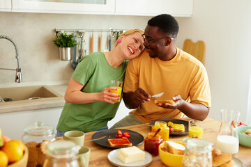 Multiracial couple enjoying breakfast together at home