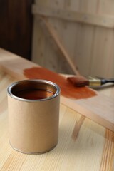 Can with wood stain on wooden surface, space for text