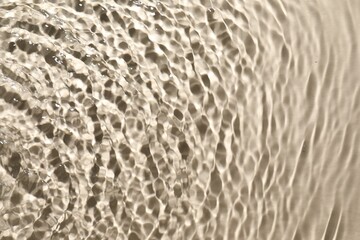 Rippled surface of clear water on beige background, top view